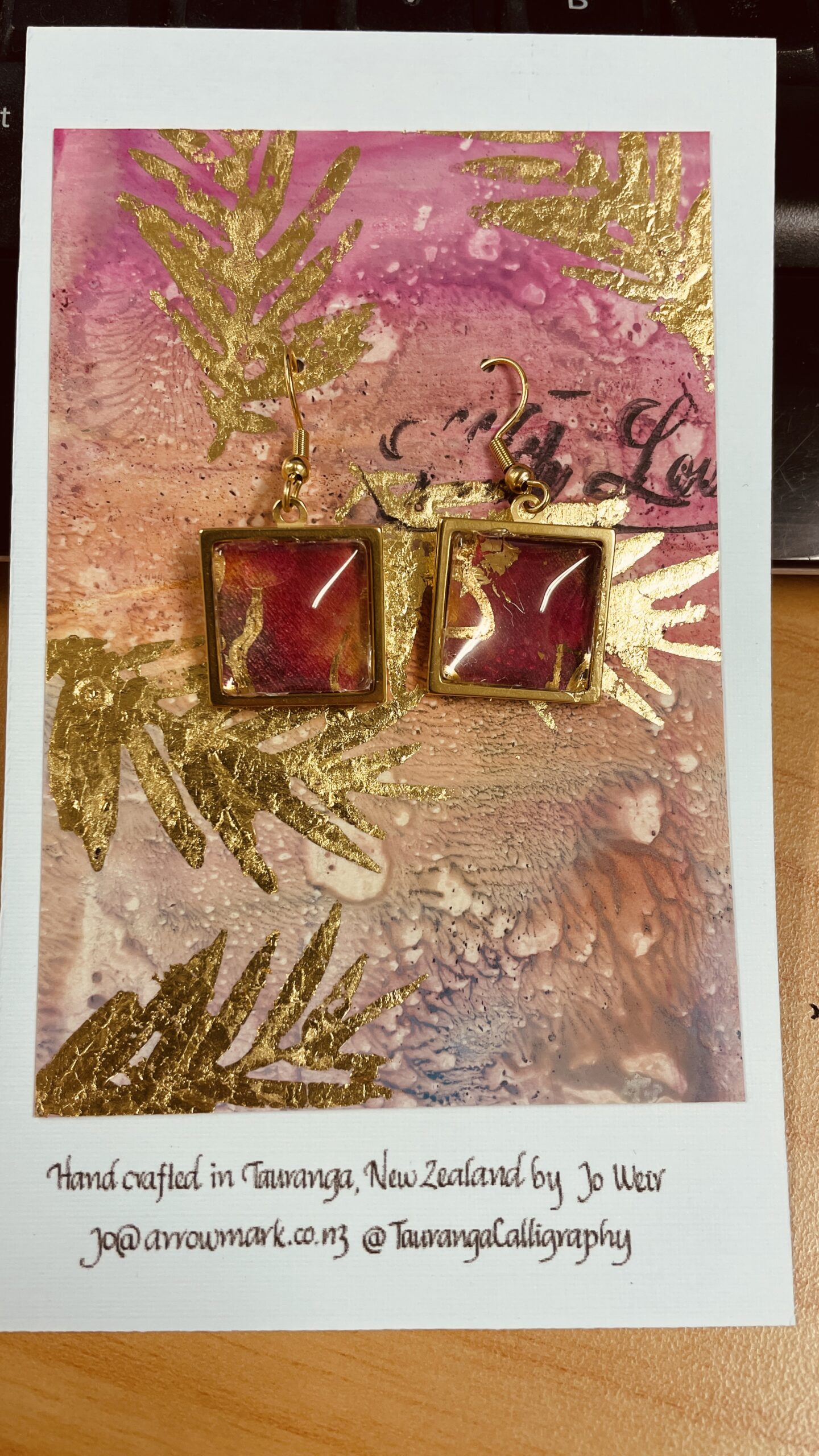 Hand made earrings, gold, red and pink alcohol ink in square metal bezels with cabochon top.