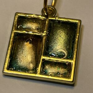 Jewellery: pendant with gold and green inks and resin set in gold metal window bezel