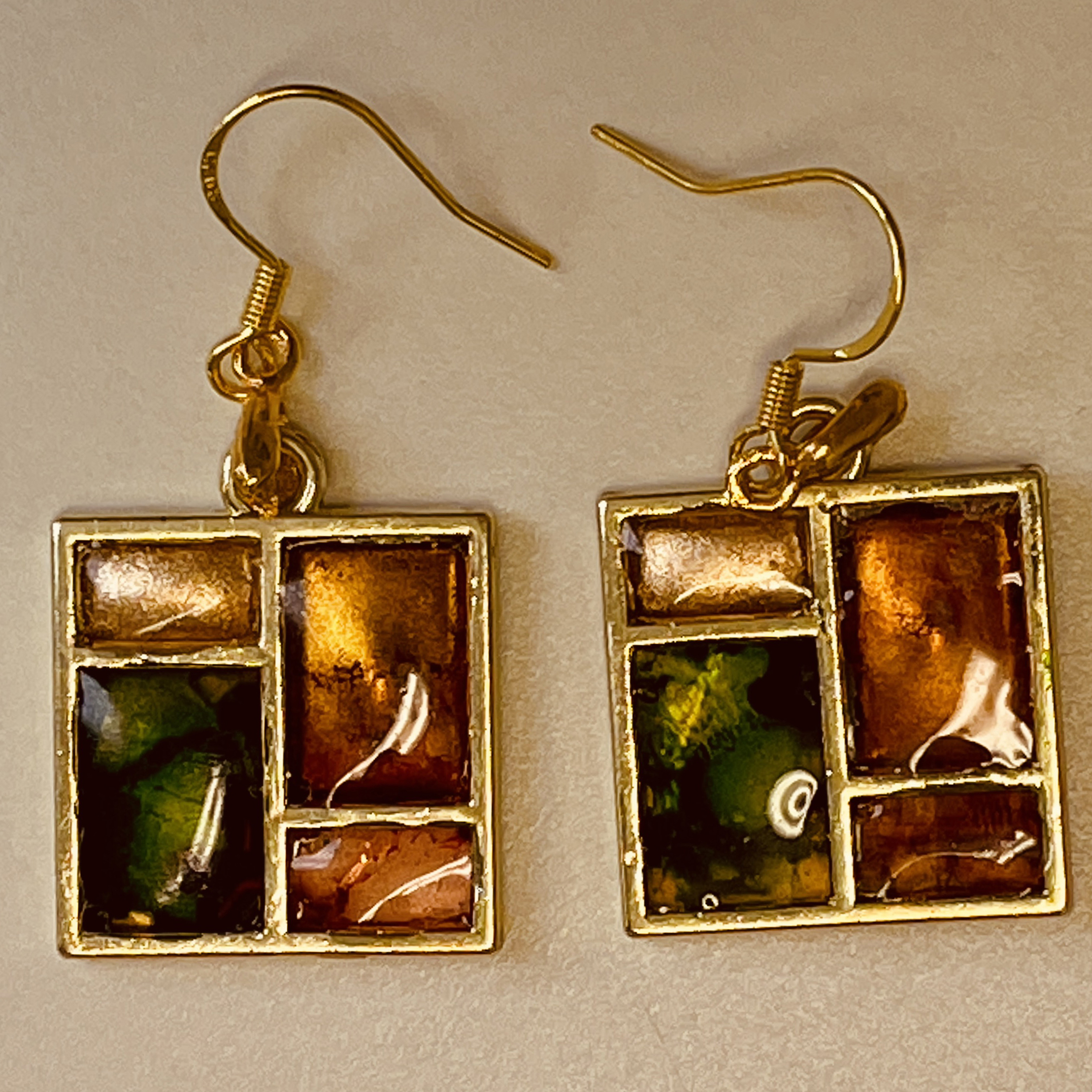 Hand made earrings crafted from green and gold ink and resin set in gold metal window bezels.