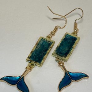 Hand crafted earrings made from colour-shift paint, alcohol ink and resin, set in gold bezels and featuring metallic blue and gold coloured whale tails.