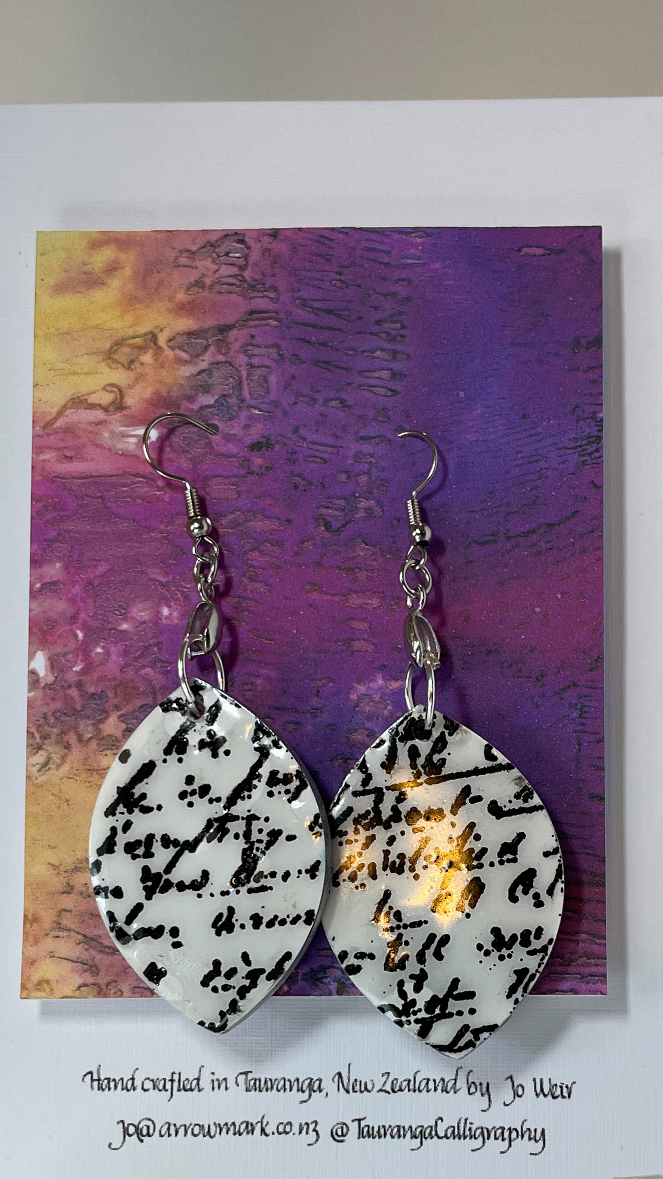 Hand crafted earrings with embossed black calligraphy, resin and silver ink surround.