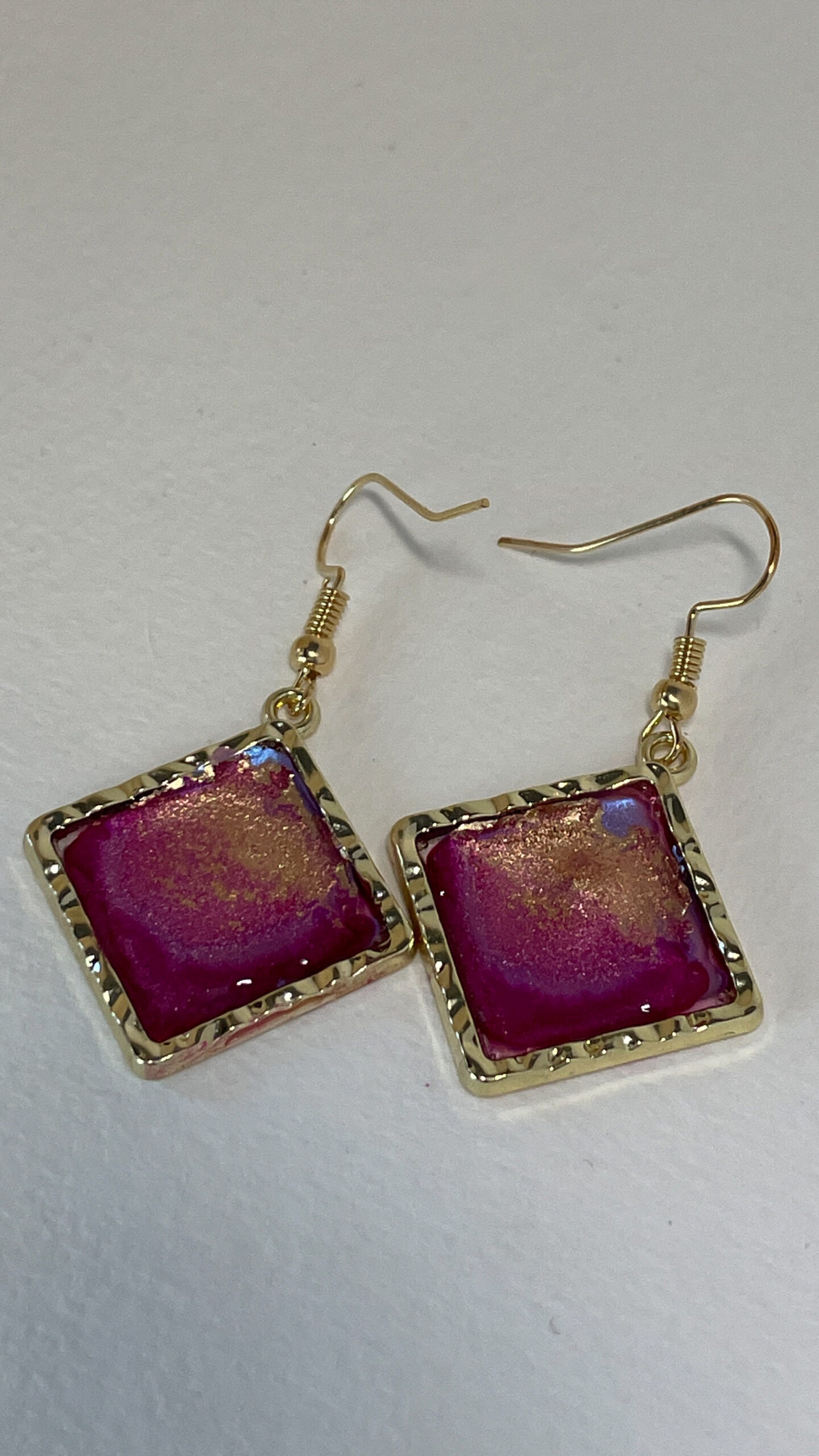 Hand crafted earrings made from alcohol ink and resin, set in gold metal bezels.