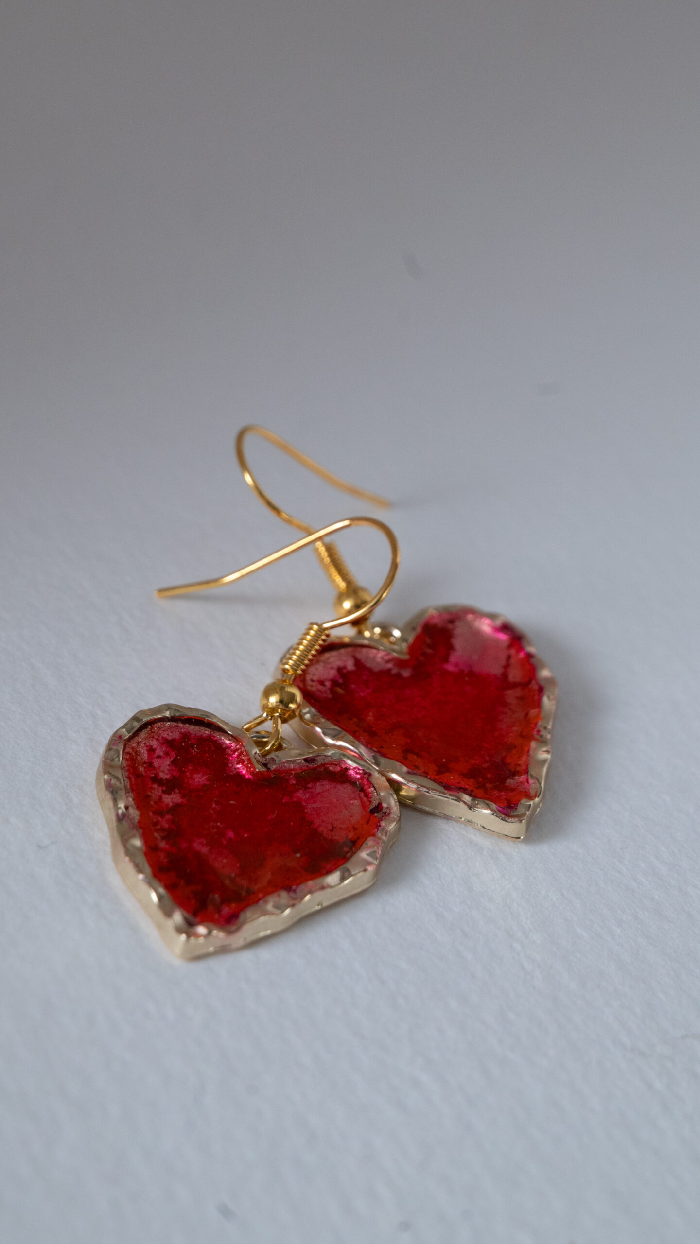 Tauranga Jewellery: Hand made earrings featuring red and gold inks and resin set in gold coloured heart shaped bezels
