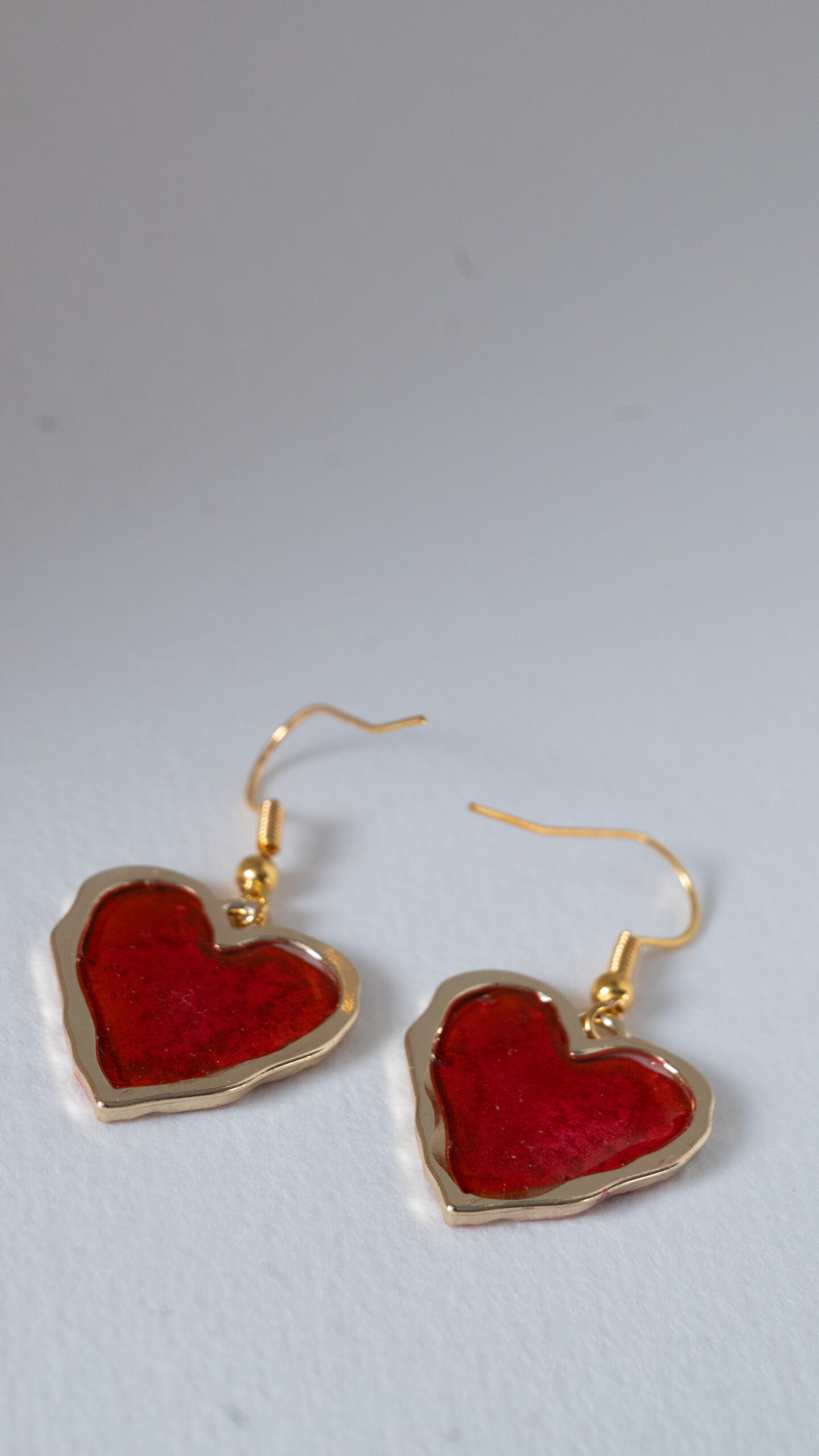 Tauranga Jewellery: Hand made earrings featuring red and gold inks and resin set in gold coloured heart shaped bezels