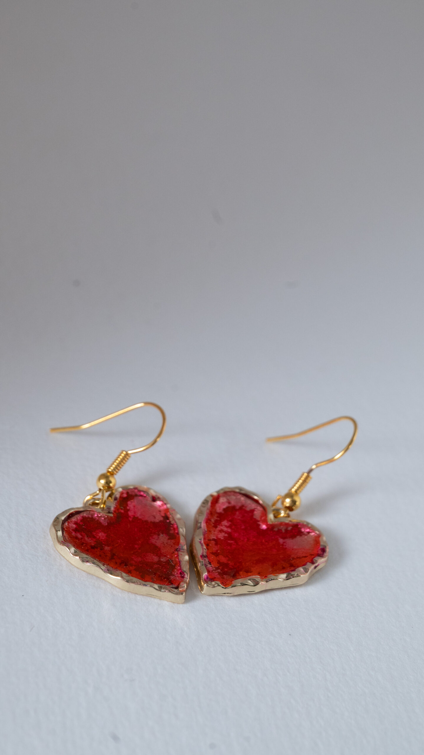 Tauranga Jewellery: Hand made earrings featuring red and gold inks and resin set in gold coloured heart shaped bezels