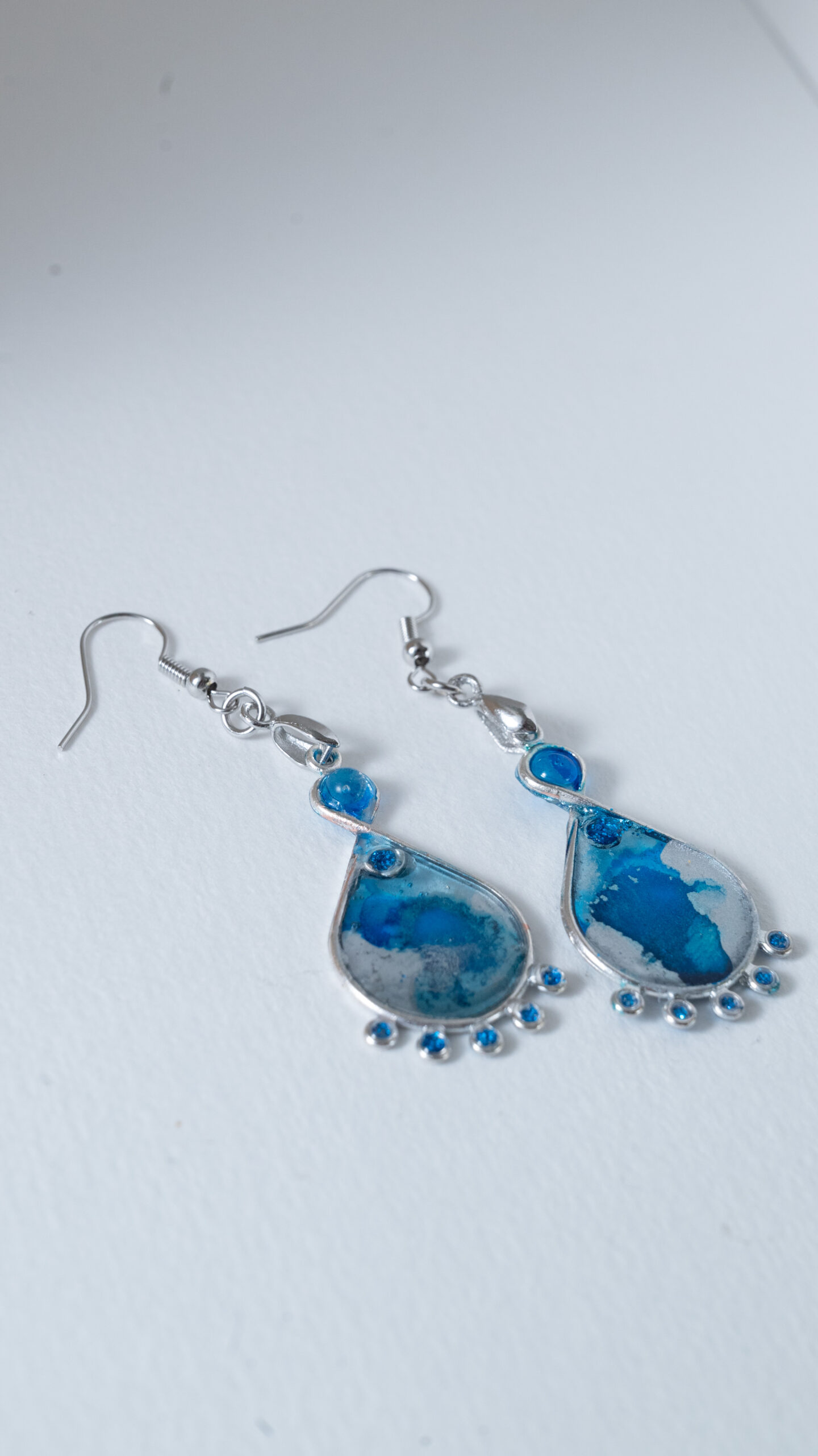 Tauranga Jewellery: Hand made earrings featuring blue and silver inks and resin set in silver coloured bezels