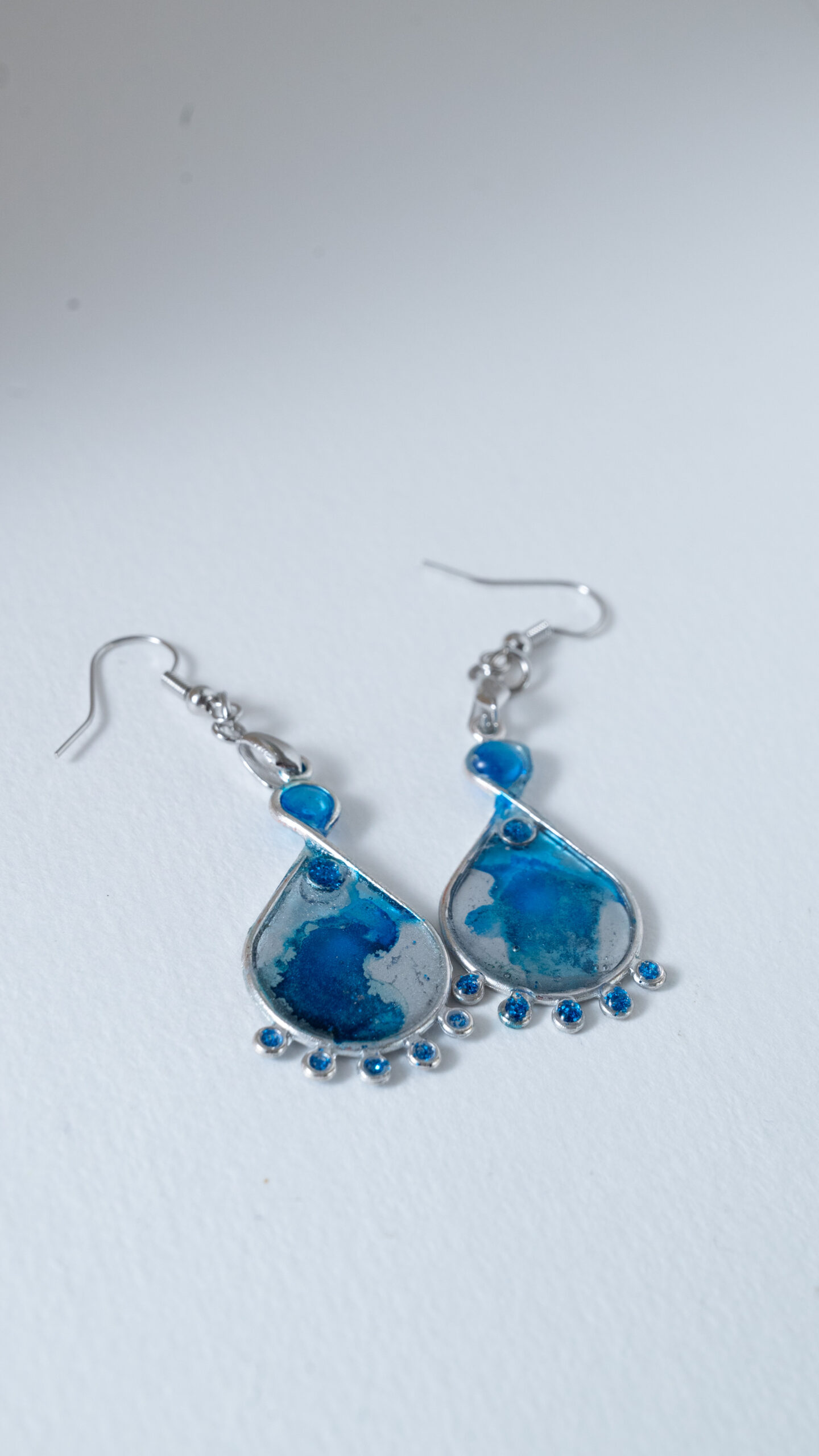 Tauranga Jewellery: Hand made earrings featuring blue and silver inks and resin set in silver coloured bezels
