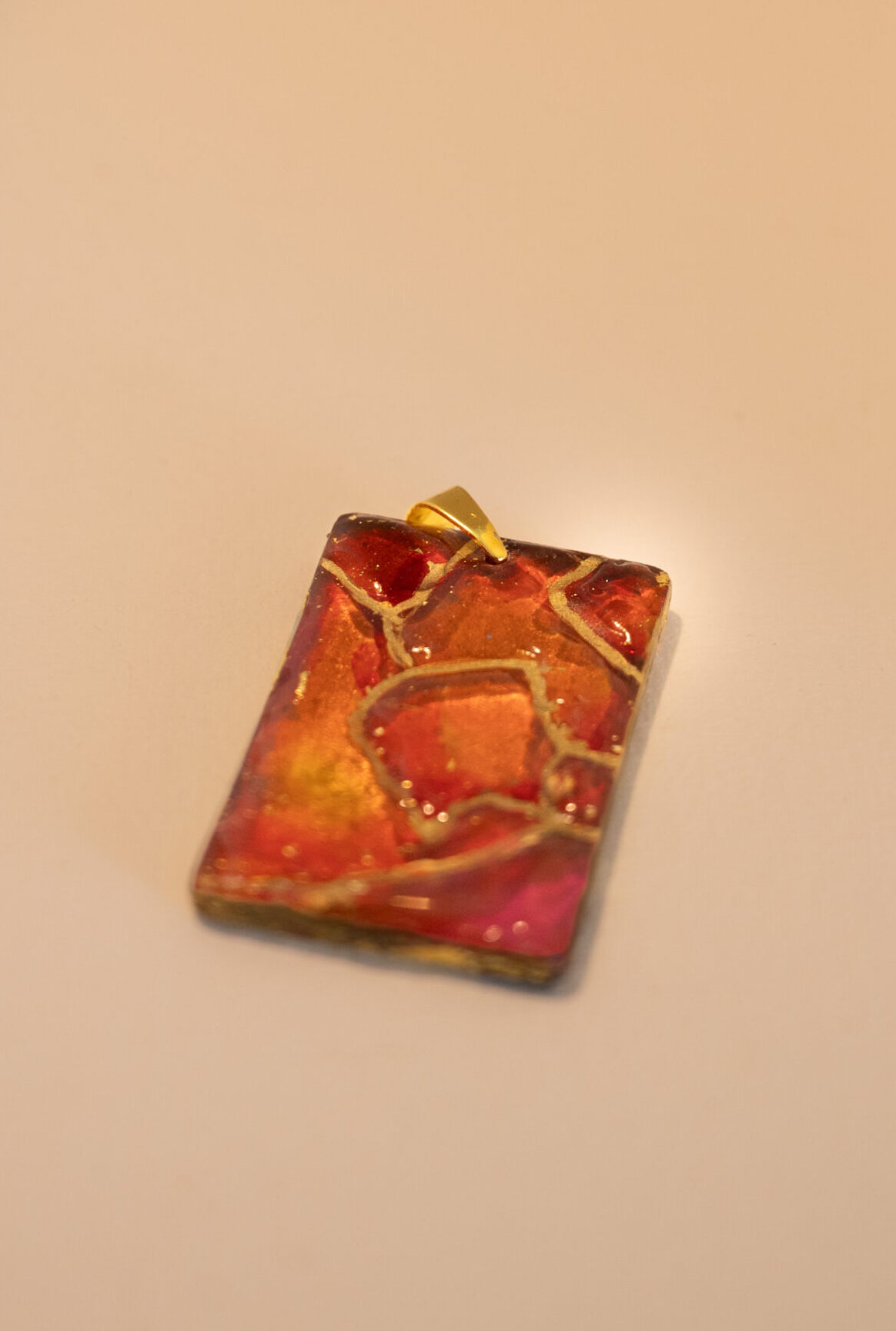 Pendant in pinks, reds and gold