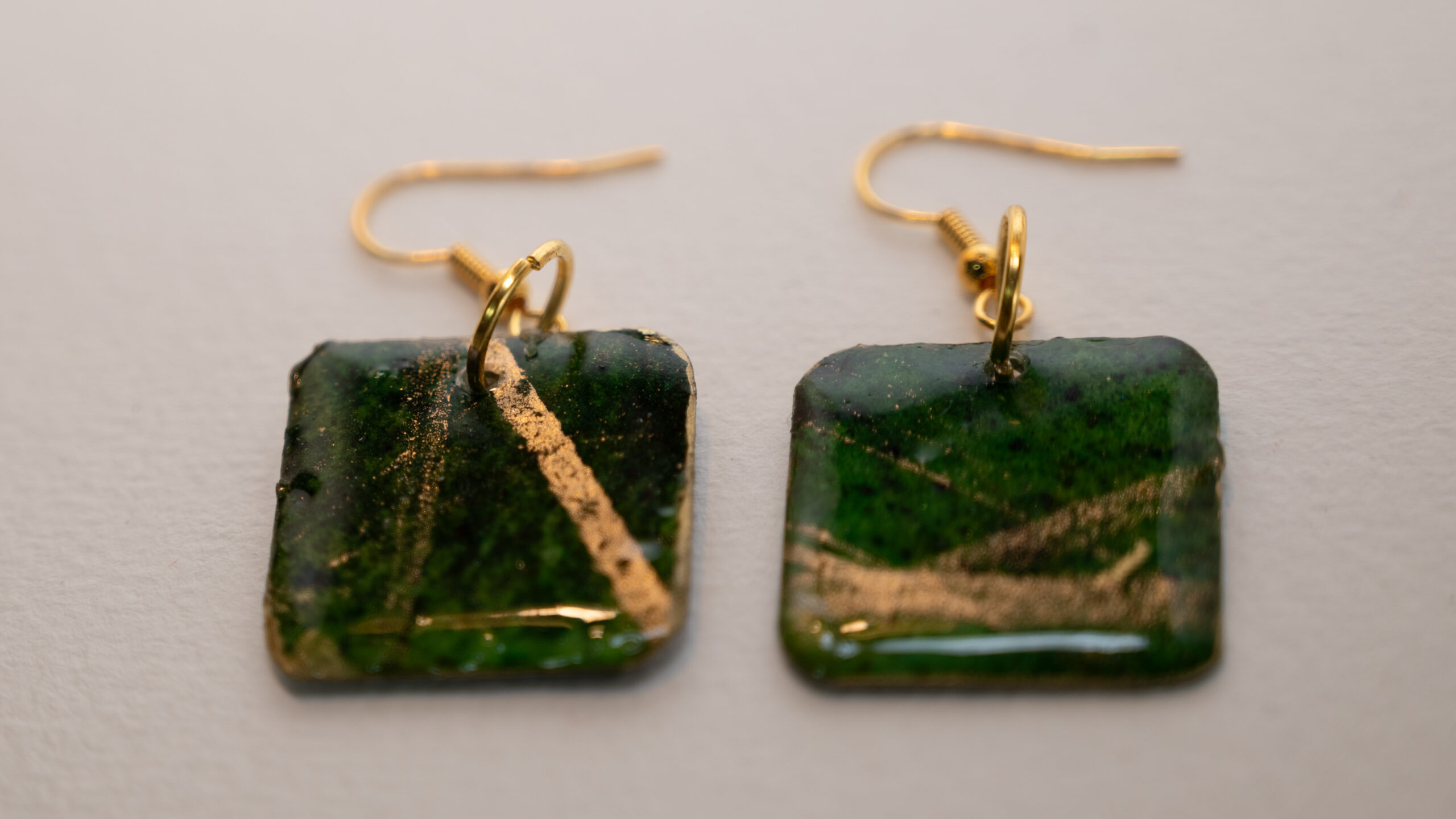 Tauranga Jewellery: hand made green and gold square shaped earrings. Crafted from card stock, ink and resin.
