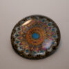 Tauranga Jewellery: Brooch featuring gold embossed mandala hand coloured with blue and orange chameleon paints and protected with resin layers