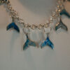 Tauranga Jewellery: Whale Tail Necklace. Silver-coloured ink and resin whale tails hand crafted and hung from a silver coloured chain link necklace.
