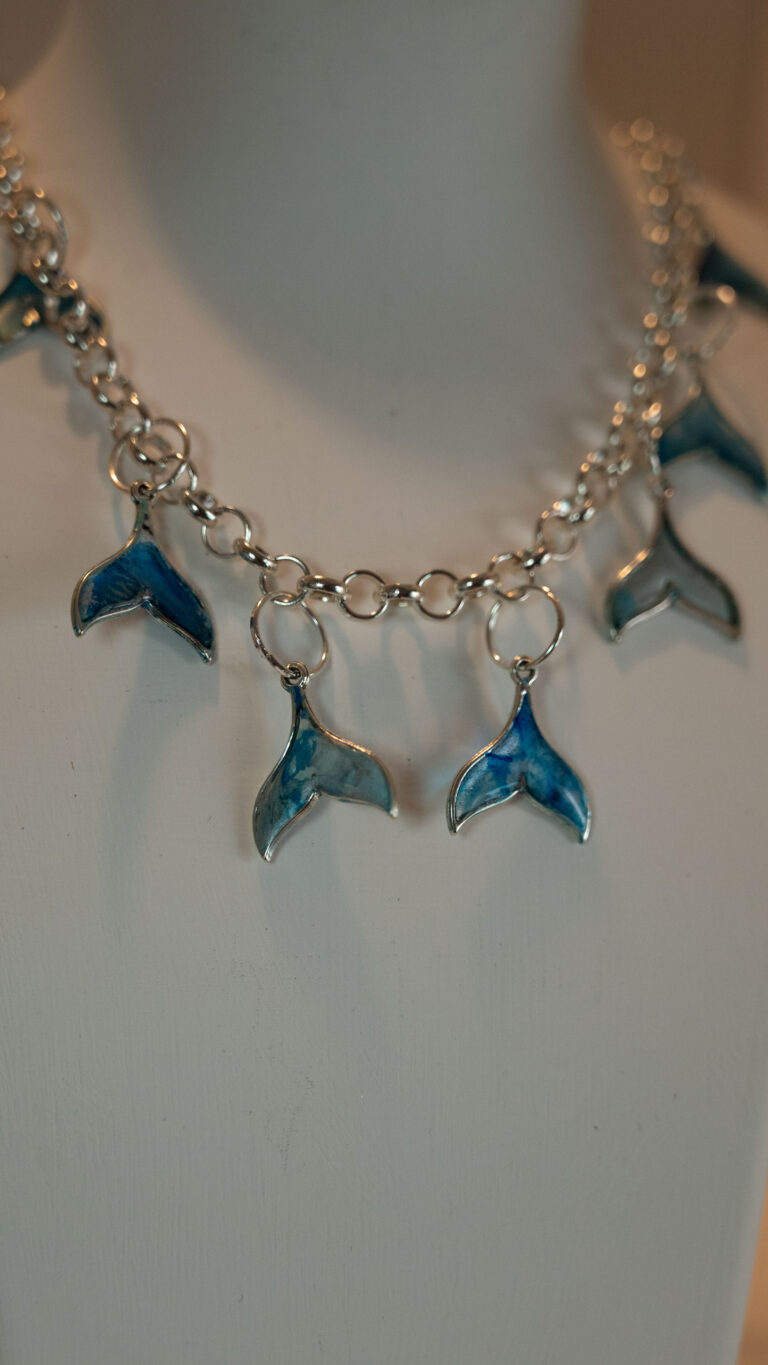 Tauranga Jewellery: Whale Tail Necklace. Silver-coloured ink and resin whale tails hand crafted and hung from a silver coloured chain link necklace.