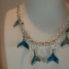 Tauranga Jewellery: Whale Tail Necklace. Silver-coloured ink and resin whale tails hand crafted and hung from a silver coloured chain link necklace.