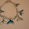 Tauranga Jewellery: Whale Tail Necklace. Silver-coloured ink and resin whale tails hand crafted and hung from a silver coloured chain link necklace.