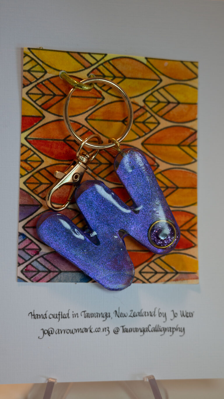 Gift: Key ring with letter ideal for a person whose name starts with W. Irridescent purpe paint encased in resin with a diamante on each side. One of a kind, hand made in Tauranga, New Zealand. 
