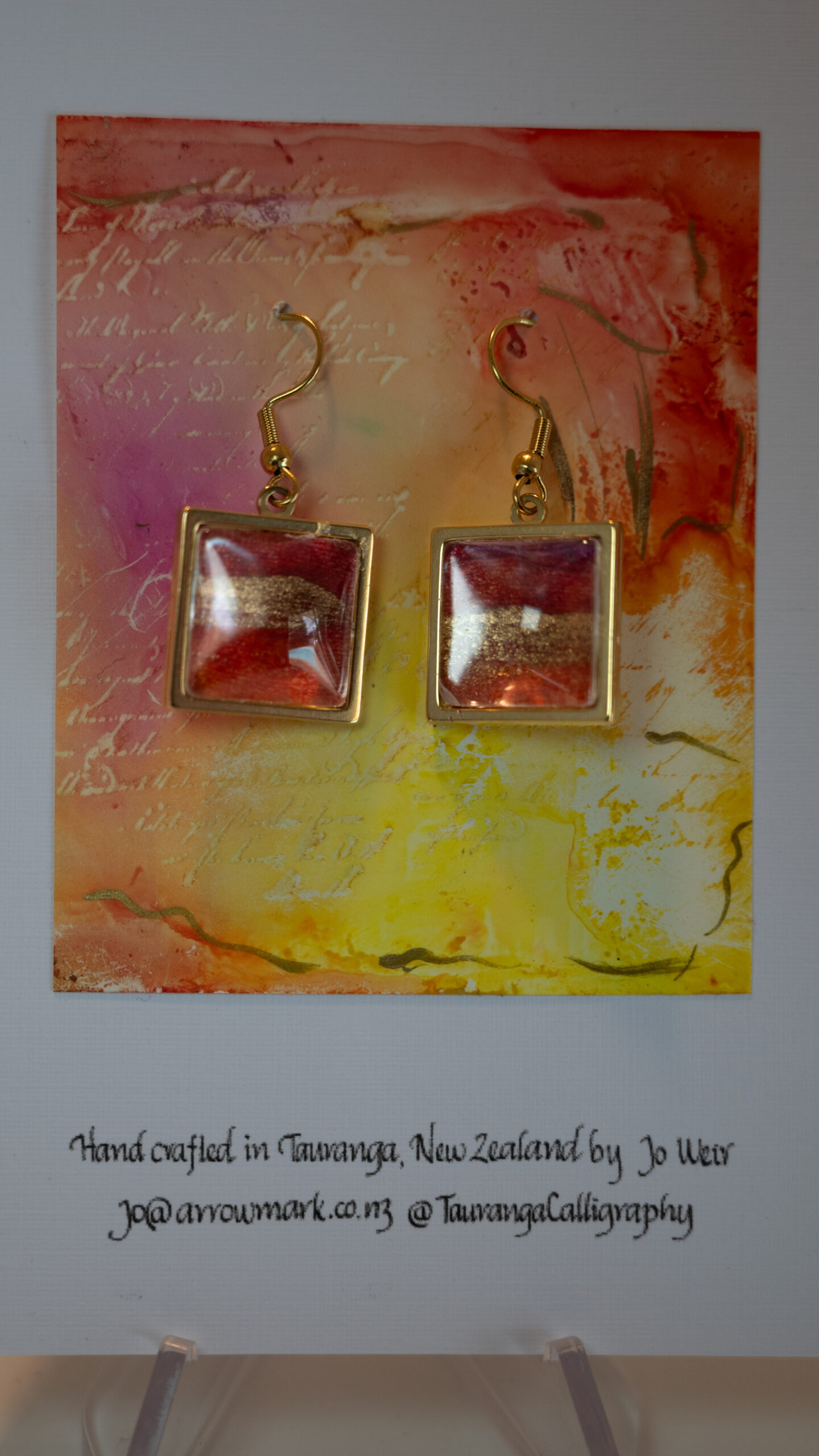 Tauranga Jewellery: Hand made earrings, gold, red and pink alcohol ink in square metal bezels with cabochon top.