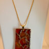 Hand made pendant featuring resin and ink with gold highlights.