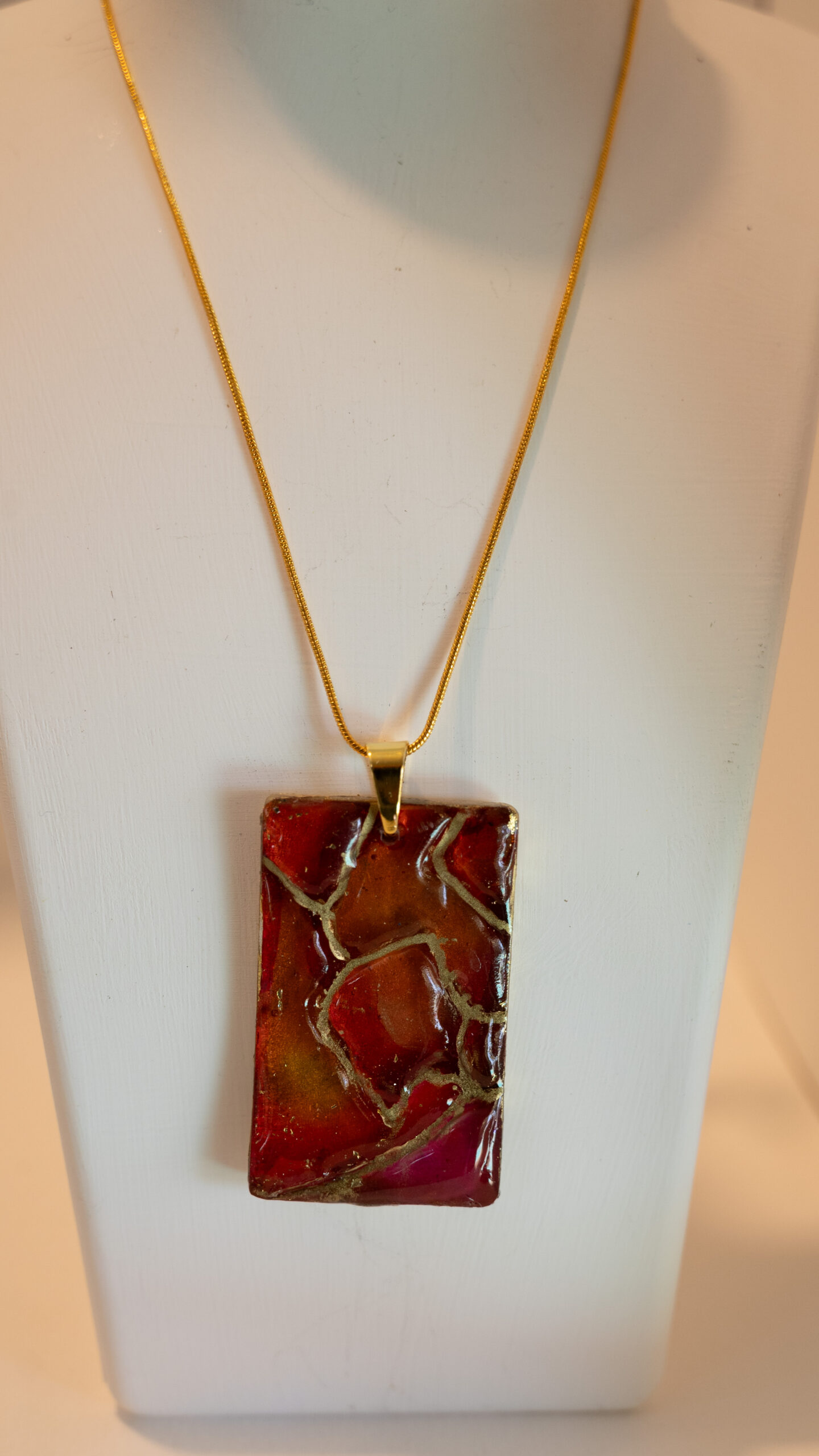Hand made pendant featuring resin and ink with gold highlights.
