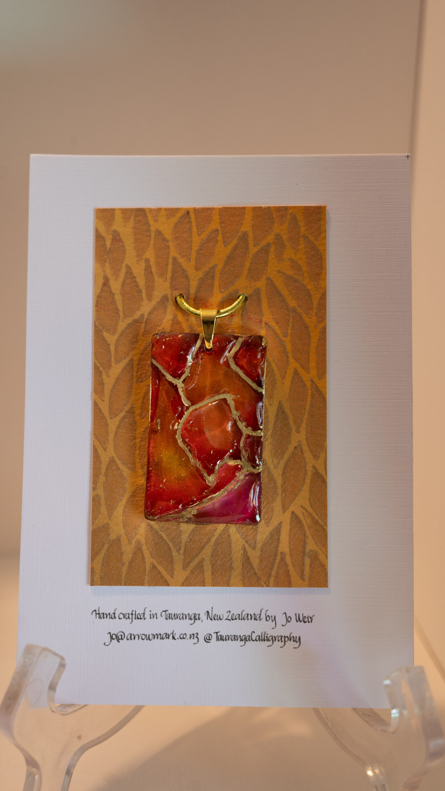 Hand made pendant featuring resin and ink with gold highlights.