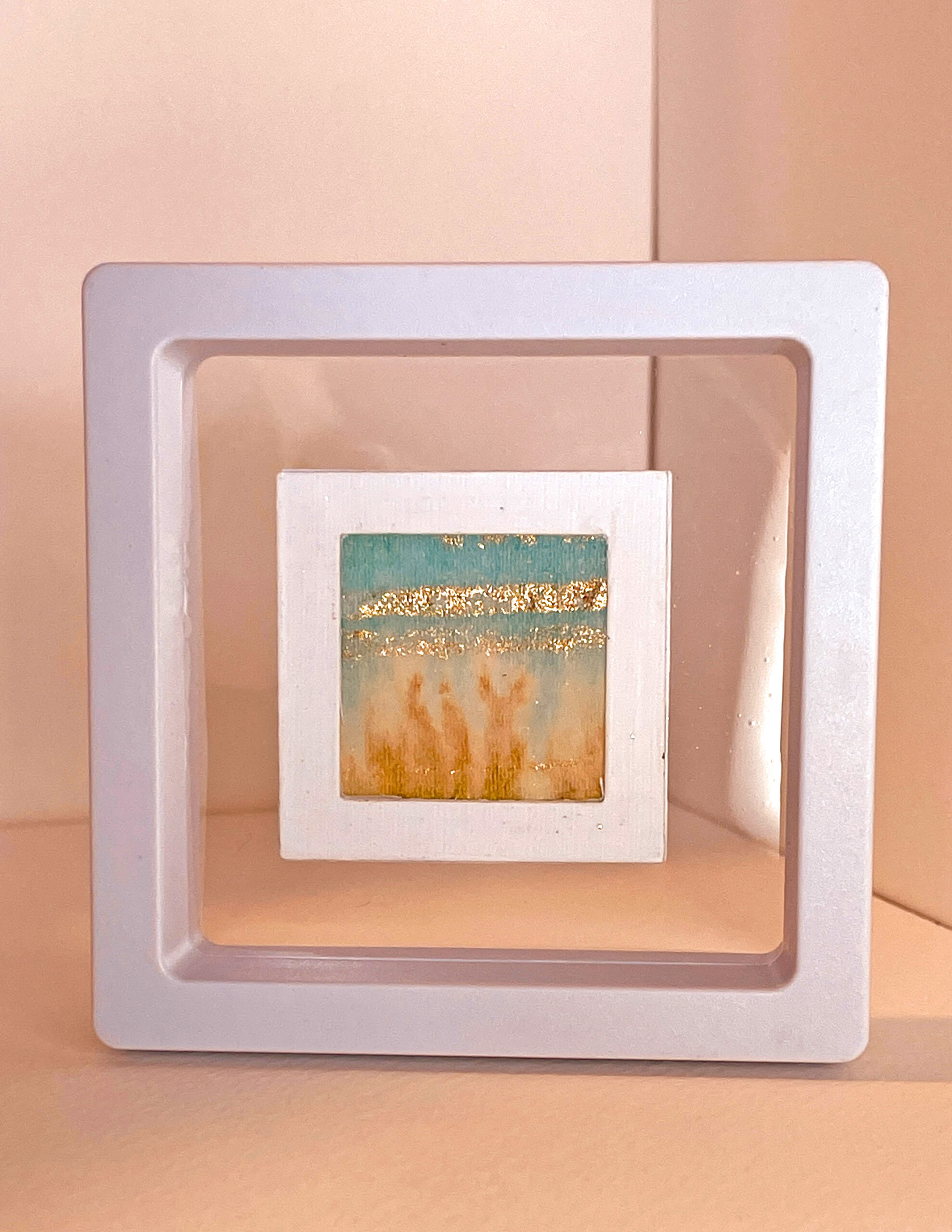 This miniature landscape was painted by hand on delicate tissue paper which is mounted within a card frame and within a transparent plastic click-frame. Gentle green and teal inks with gold highlights. Ideal for a shelf or desktop.