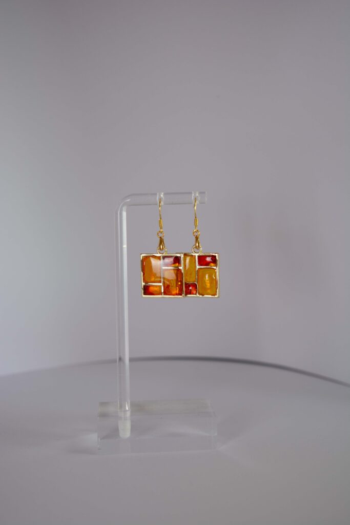 Jewellery: Earrings. Gold metalframes with orange, red and yellow windows.
