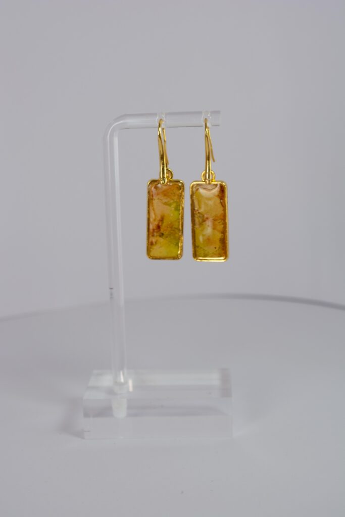Hand crafted earrings ing golds, greens and yellows. Ink, resin and metal.