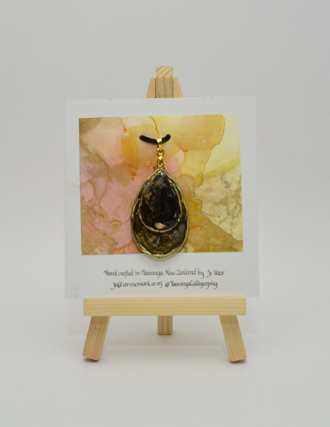 Hand crafted tear drop shaped pendant made from gold and black inks, set in a gold bezel and finished with shiny resin. Double sided.