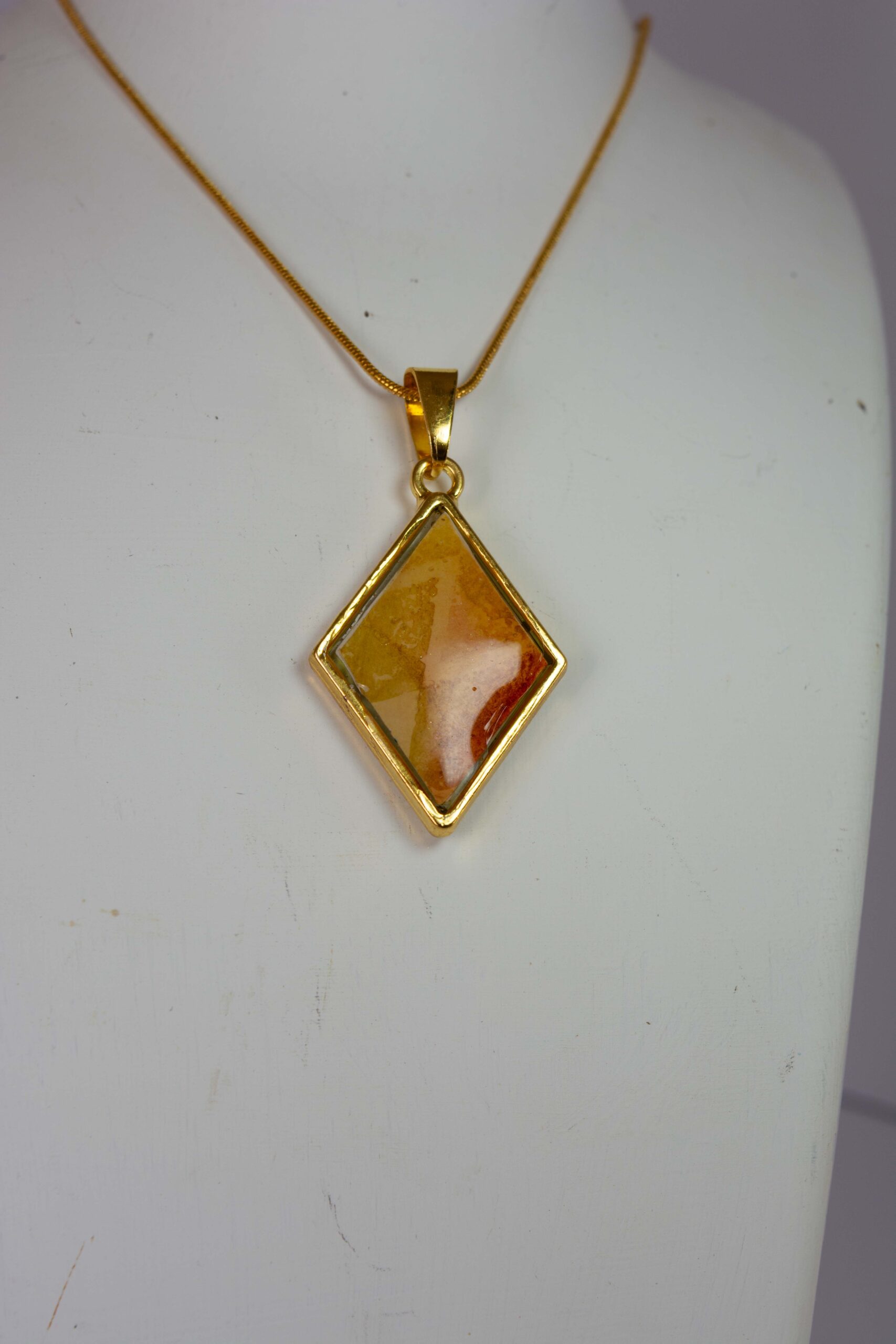 Diamond shaped double sided pendant in greens, yellows and oranges.