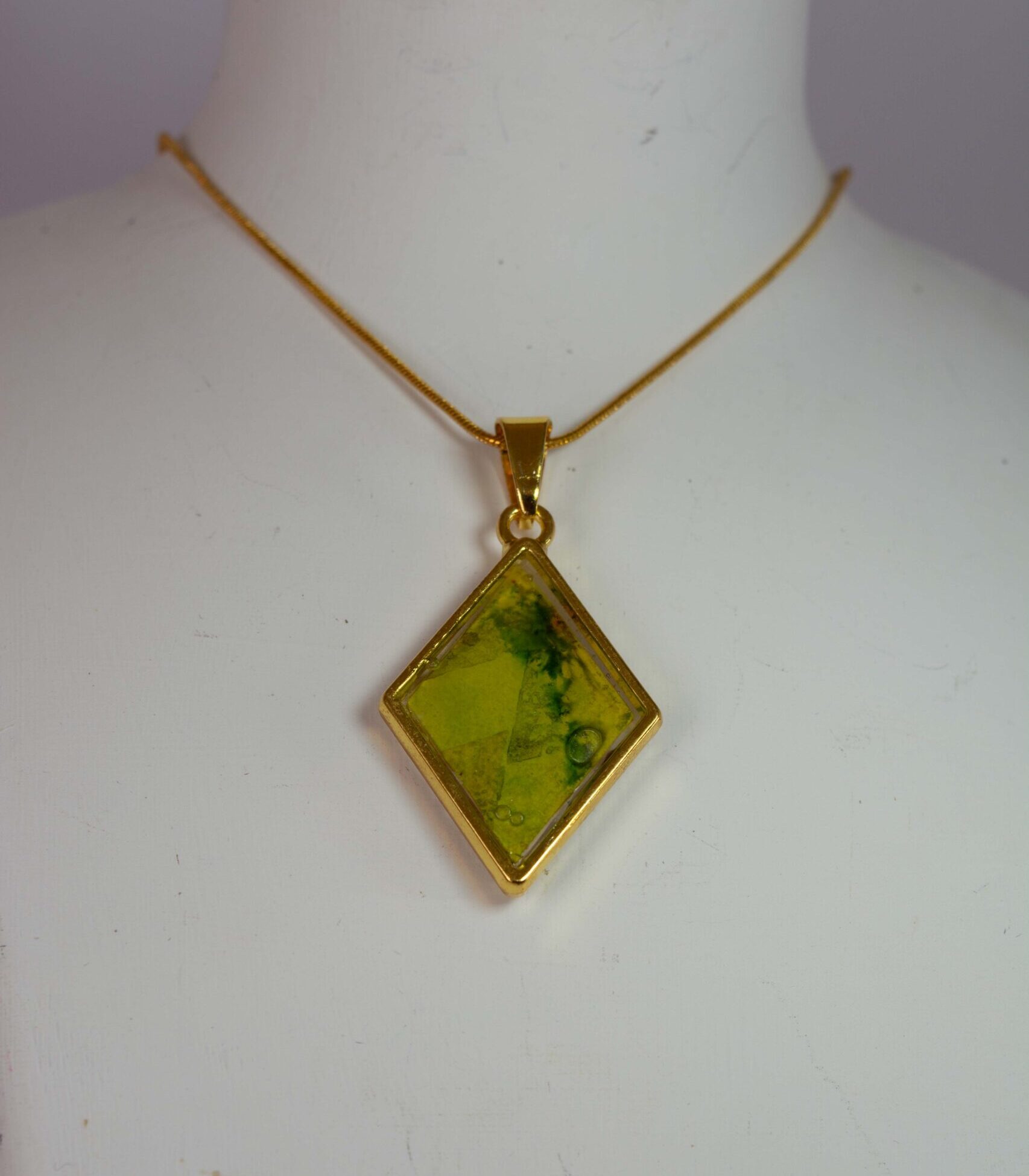 Diamond shaped double sided pendant in greens, yellows and oranges.