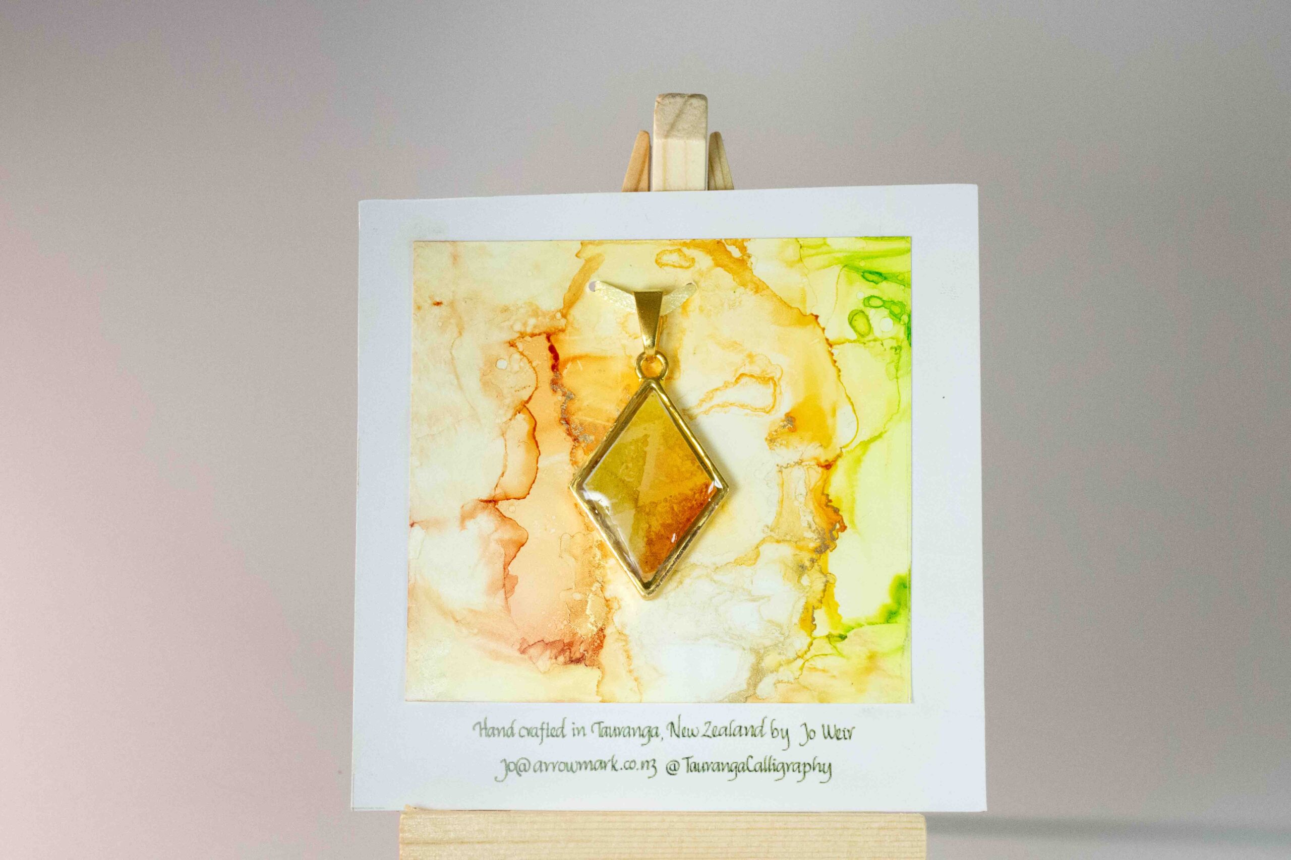 Diamond shaped double sided pendant in greens, yellows and oranges.