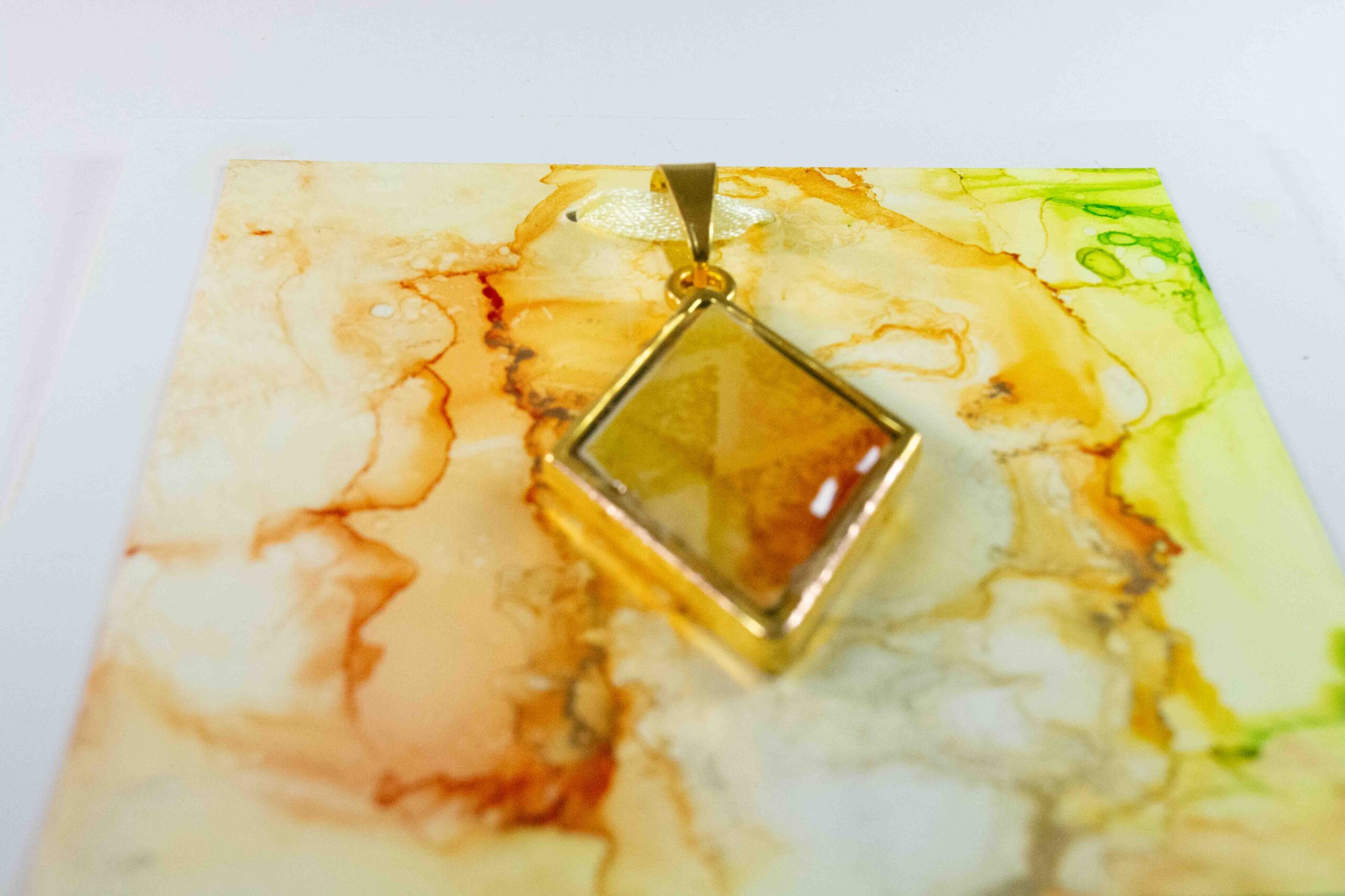 Diamond shaped double sided pendant in greens, yellows and oranges.