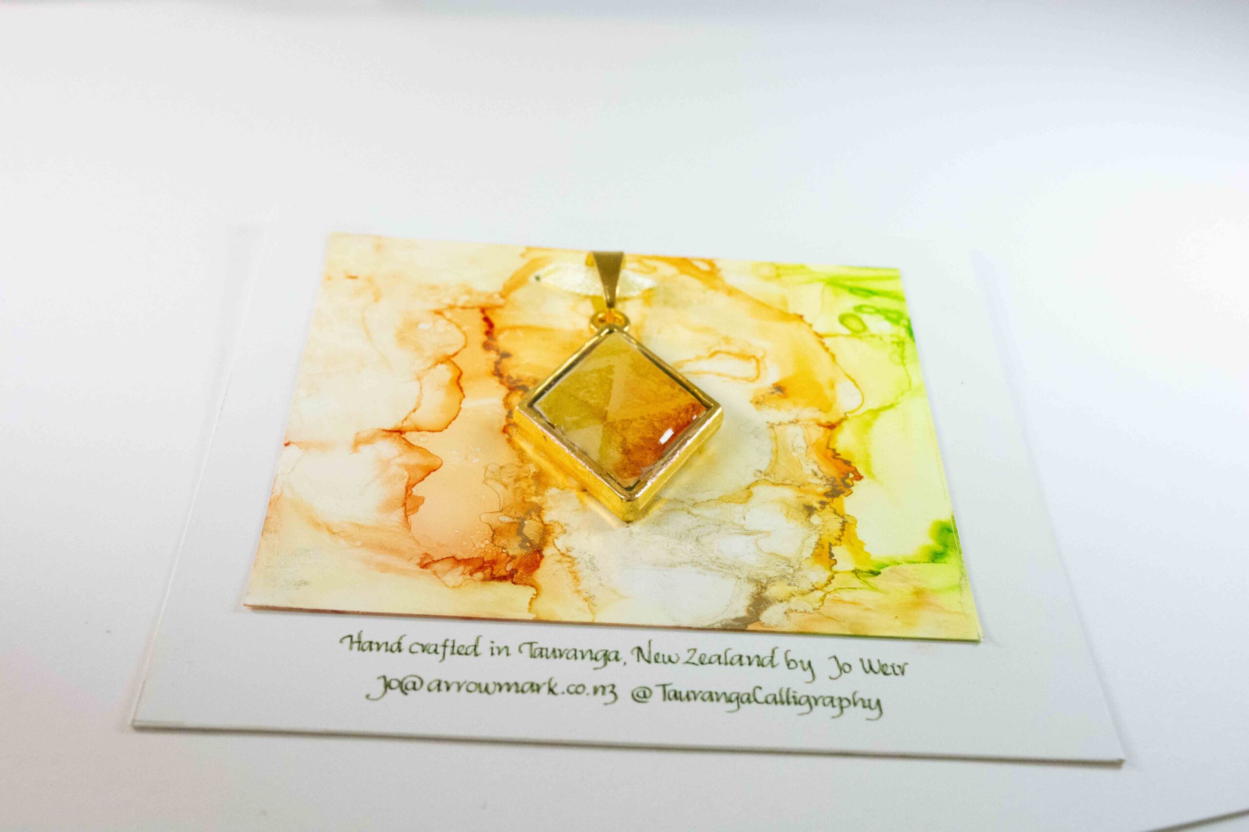 Diamond shaped double sided pendant in greens, yellows and oranges.