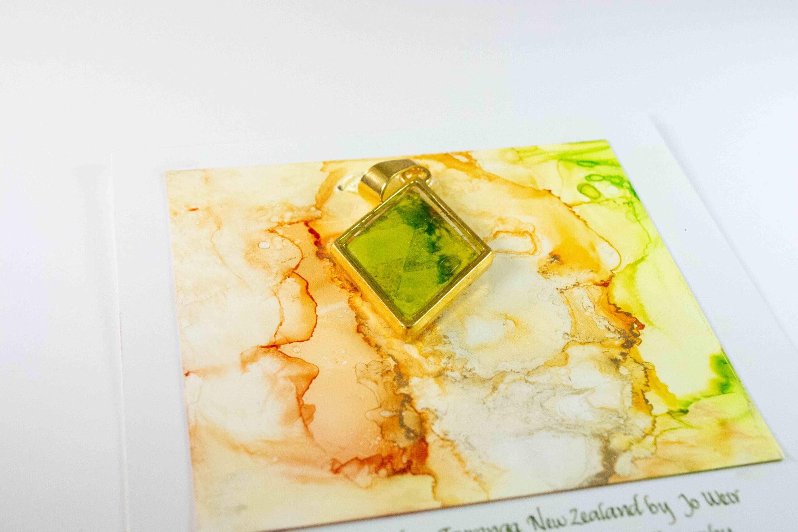 Diamond shaped double sided pendant in greens, yellows and oranges.