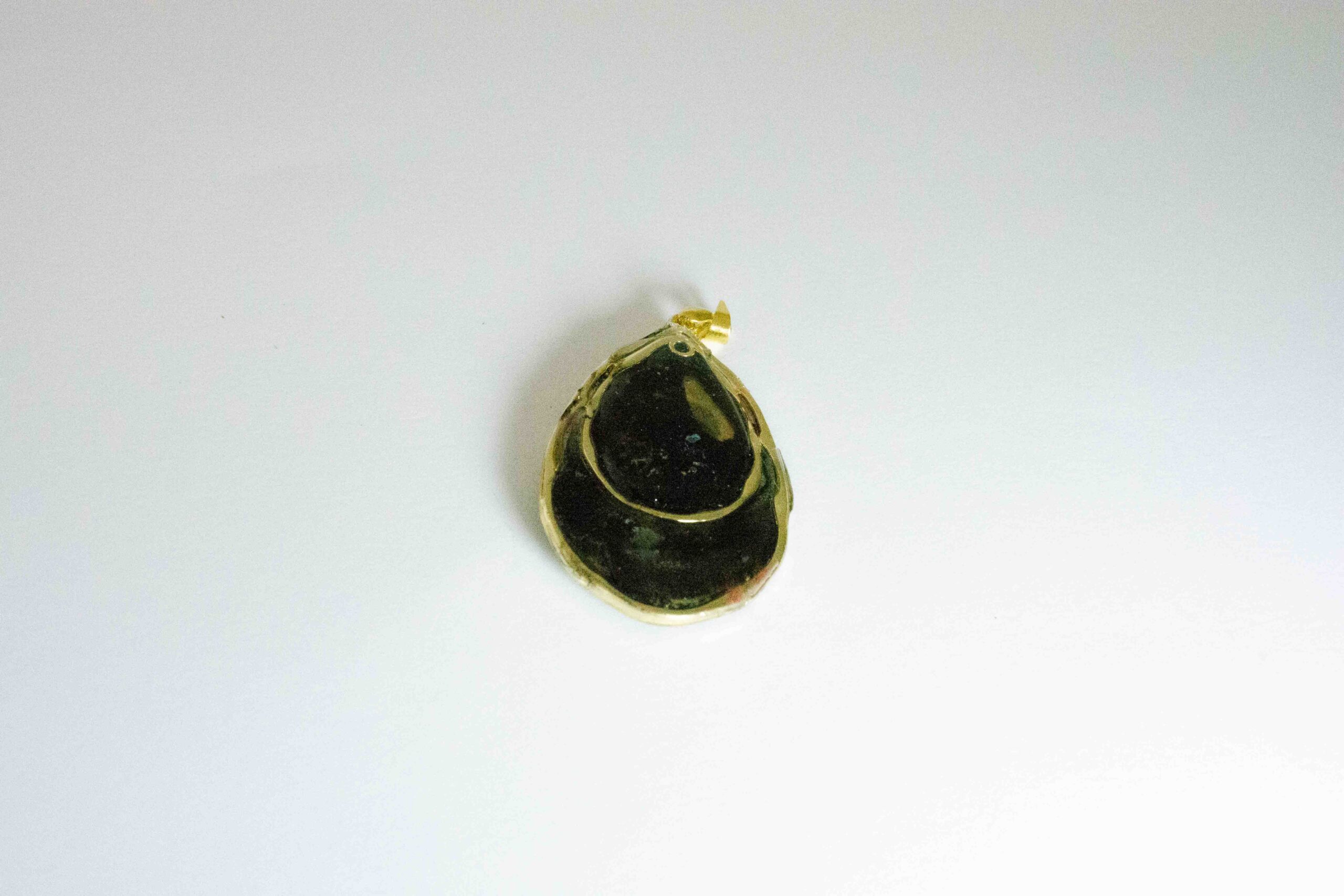 Hand crafted tear drop shaped pendant made from gold and black inks, set in a gold bezel and finished with shiny resin. Double sided.