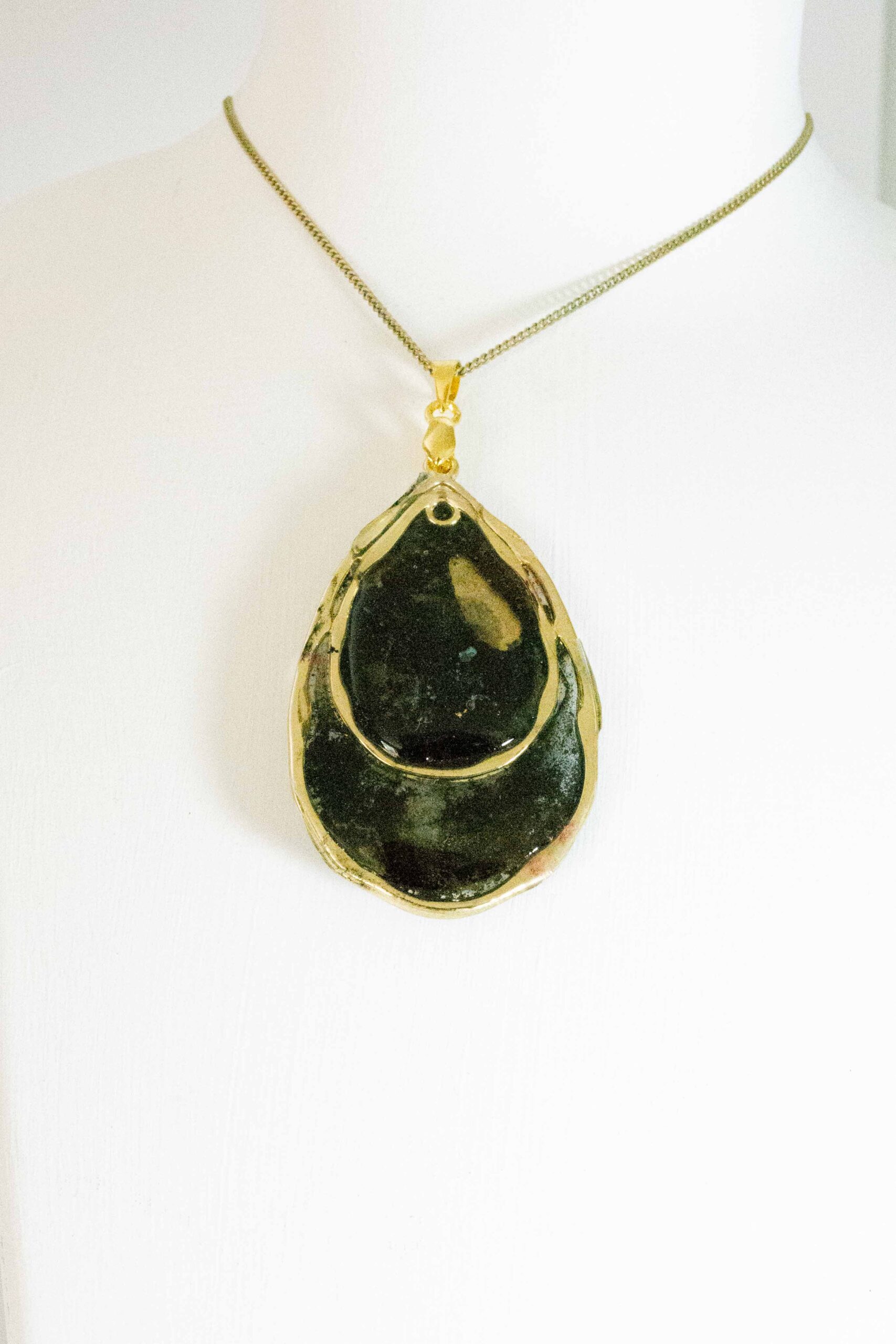 Hand crafted tear drop shaped pendant made from gold and black inks, set in a gold bezel and finished with shiny resin. Double sided.