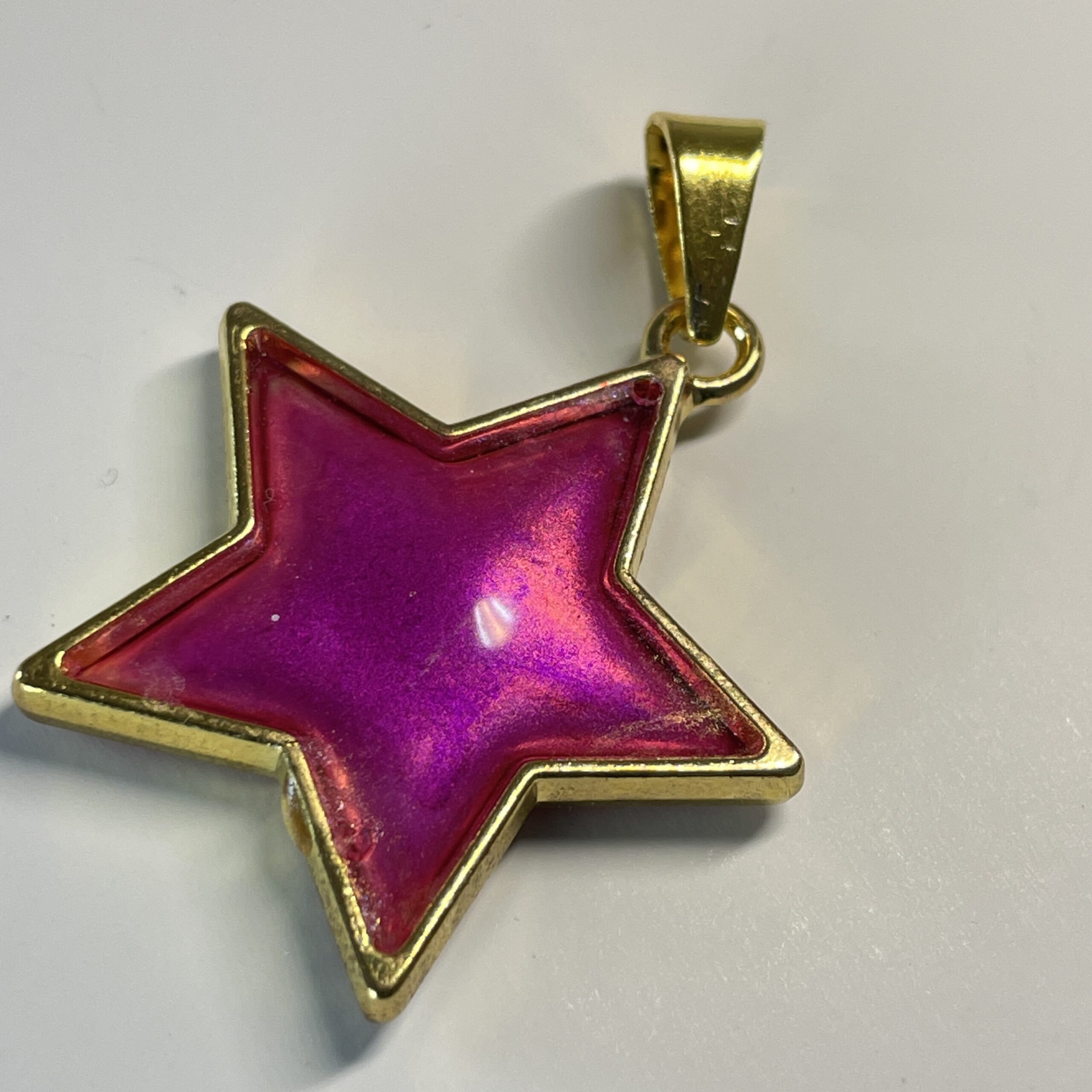 Hand made pendant featuring an irridescent pink star