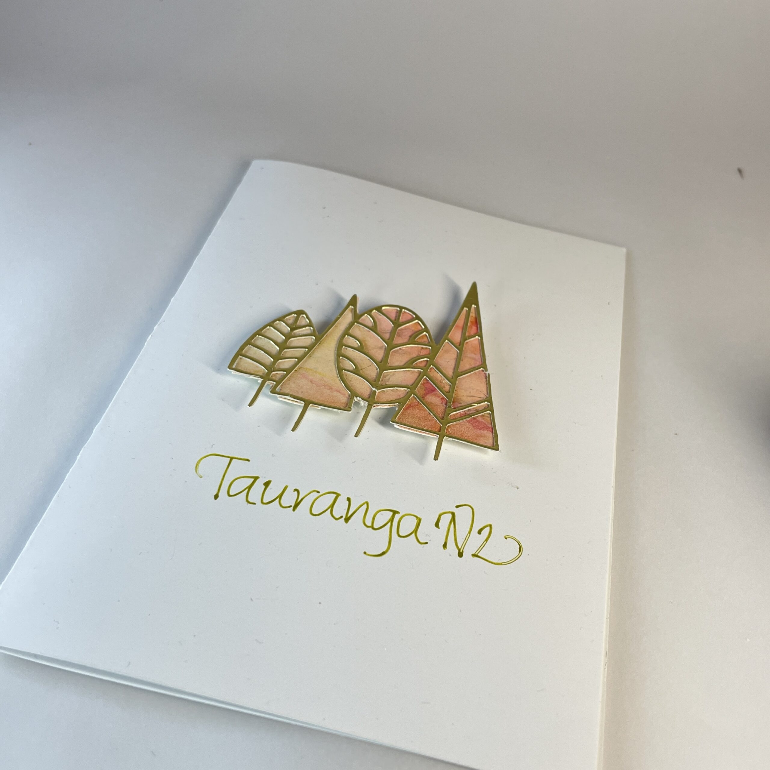 Greeting Card: Tauranga NZ Hand made greeting card featuring four die cut gold trees filled with alcohol ink art and calligraphy text "Tauranga, NZ".