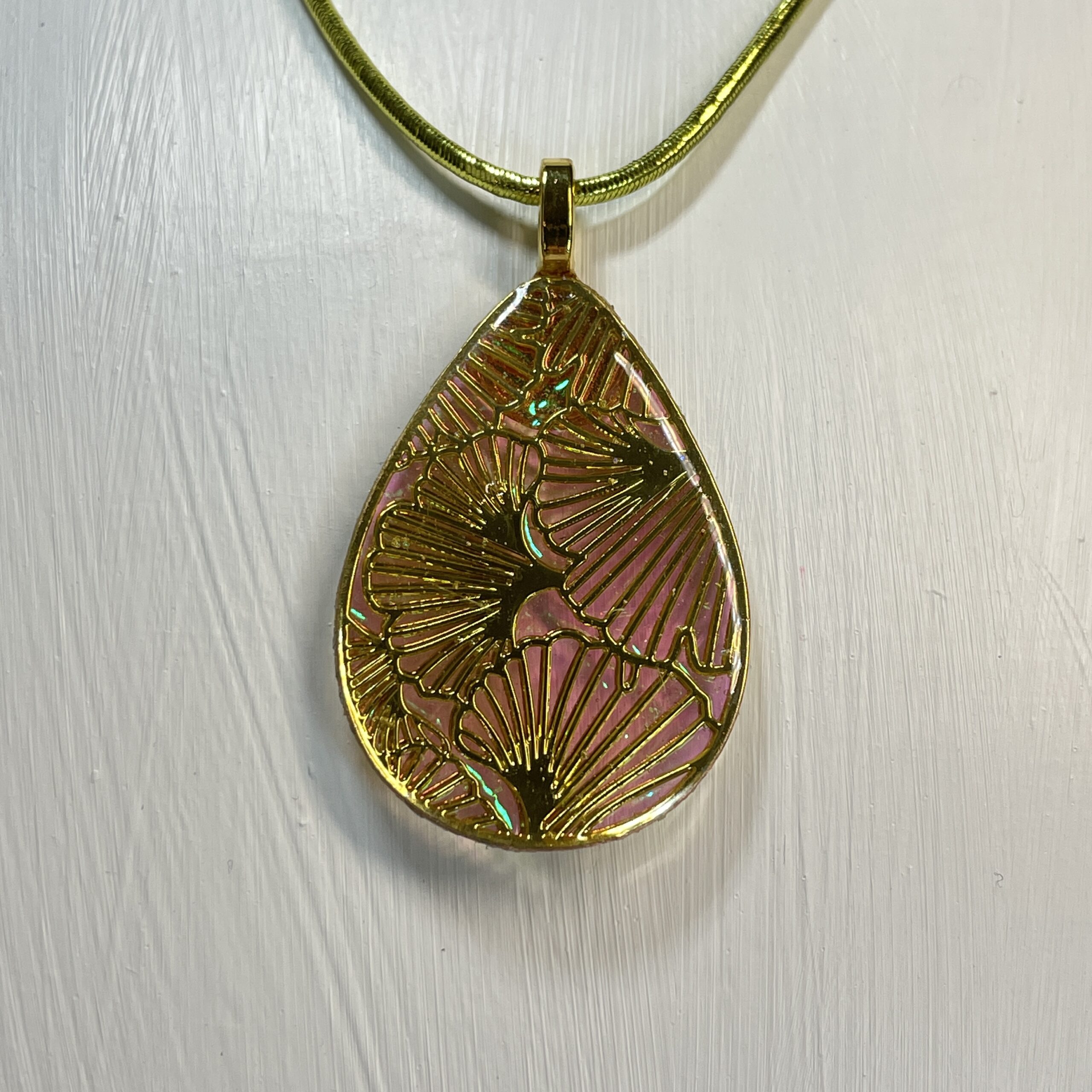 Pendant crafted from metal, dichroic film and resin