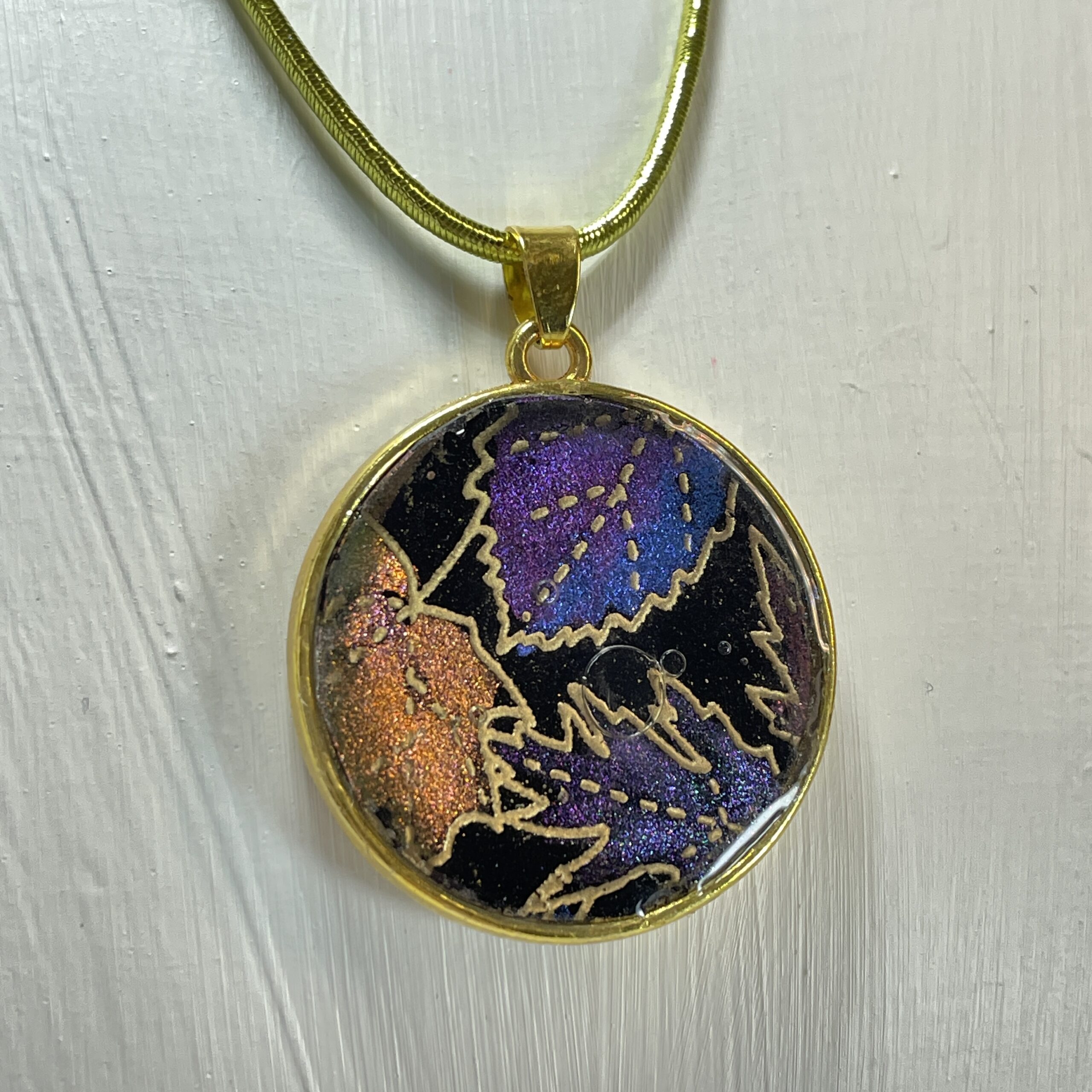 Hand made pendant featuring colour-changing hand painted ink and resin centre.