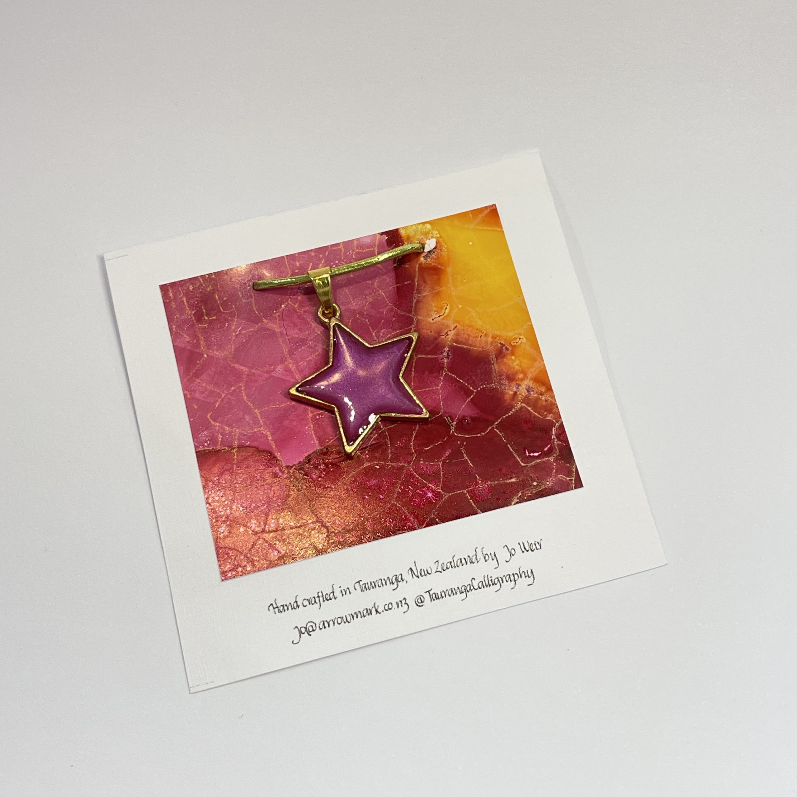 Hand made pendant featuring an irridescent pink star