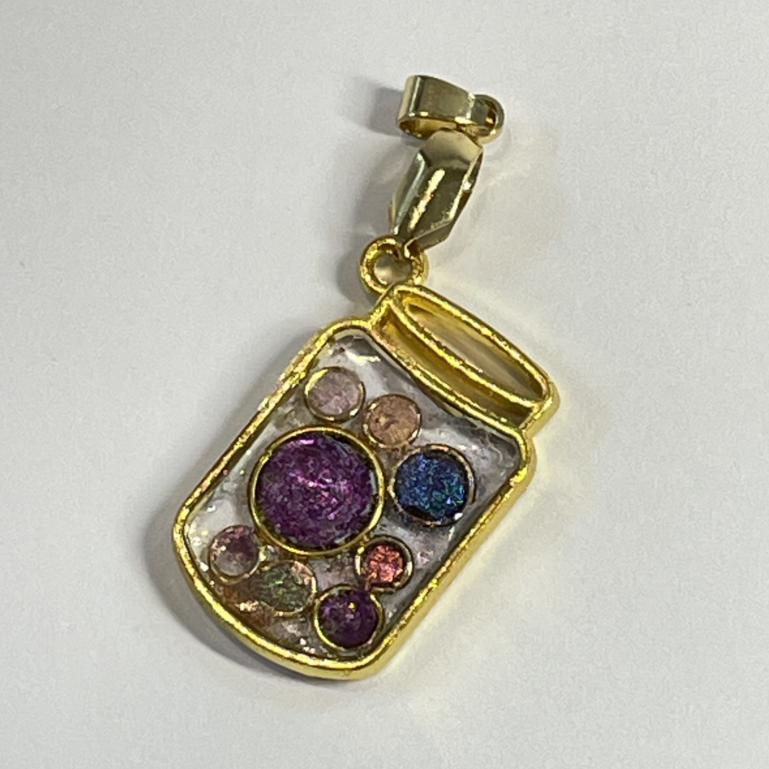 Hand made jar pendant featuring hand crafted sparkly bubbles encased in gold coloured metal Hand made jar pendant featuring hand crafted sparkly bubbles encased in gold coloured metal