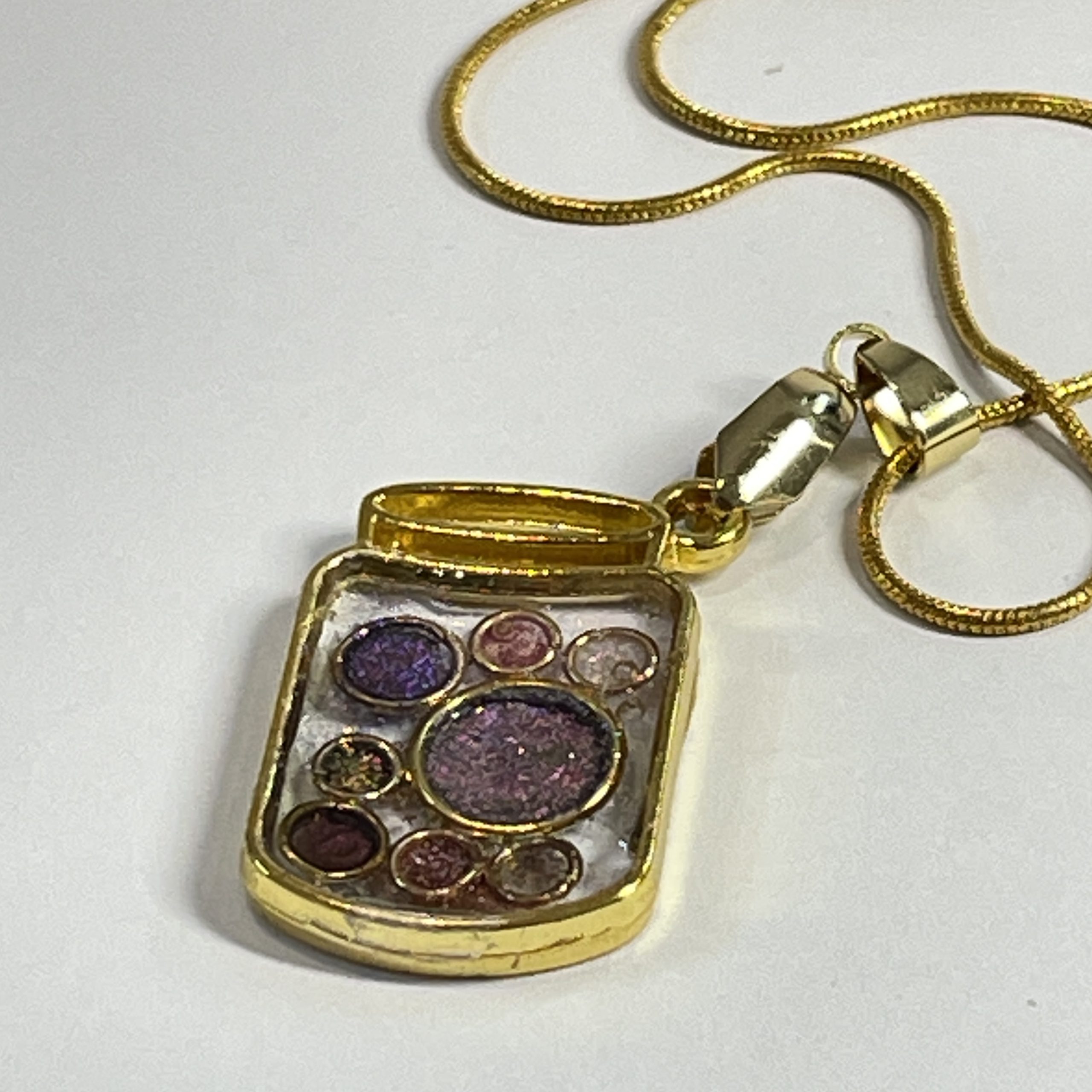 Hand made jar pendant featuring hand crafted sparkly bubbles encased in gold coloured metal Hand made jar pendant featuring hand crafted sparkly bubbles encased in gold coloured metal
