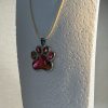 Hand made pendant featuring chameleon colour shift pigment in a silver-coloured pet paw bezel