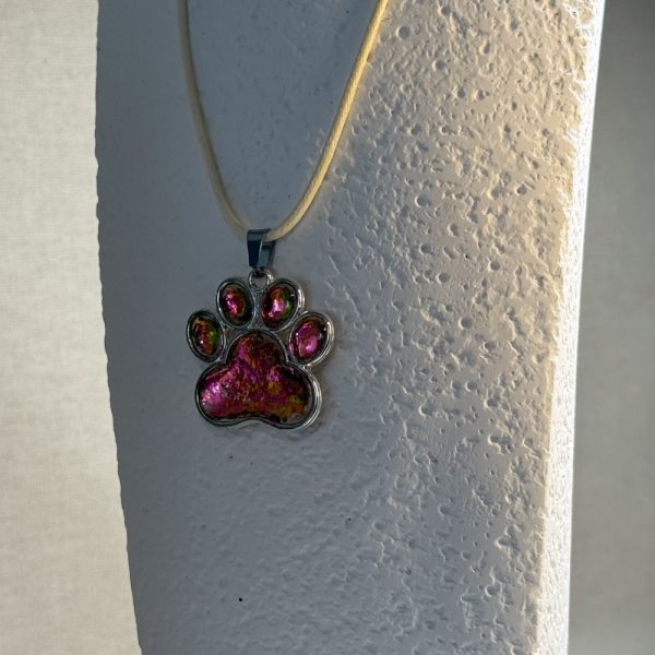 Hand made pendant featuring chameleon colour shift pigment in a silver-coloured pet paw bezel