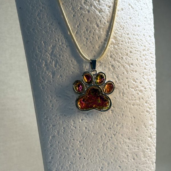 Hand made pendant featuring chameleon colour shift pigment in a silver-coloured pet paw bezel