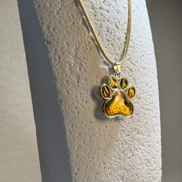 Hand made pendant featuring chameleon colour shift pigment in a silver-coloured pet paw bezel