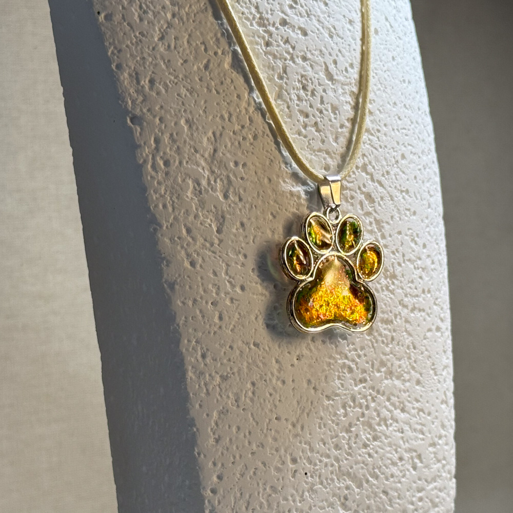 Hand made pendant featuring chameleon colour shift pigment in a silver-coloured pet paw bezel Hand made pendant featuring chameleon colour shift pigment in a silver-coloured pet paw bezel