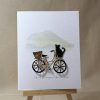 Mount Maunganui greeting card featuring a hand made bicycle with a basket and a black cat